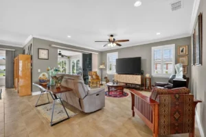 A spacious living room with comfortable seating, a large TV, and tasteful decor, featuring warm lighting and neutral tones.