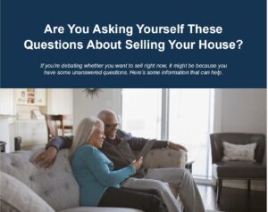 A couple sits comfortably on a couch, discussing questions related to selling their house, in a bright, modern living space.