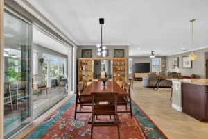 A modern dining area featuring a wooden table, stylish chairs, and open layout leading to a cozy living space.